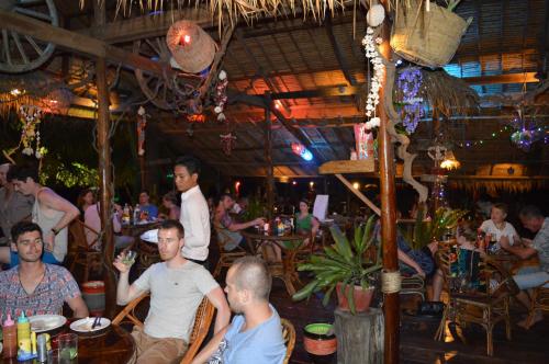 een groep mensen die aan tafels in een restaurant zitten bij Palm Beach Bungalow Resort in Koh Rong Island