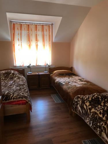 two beds in a room with a window at Vila de lux in Bela Crkva