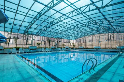 a large indoor swimming pool with a glass ceiling at Asia International Hotel Guangdong in Guangzhou