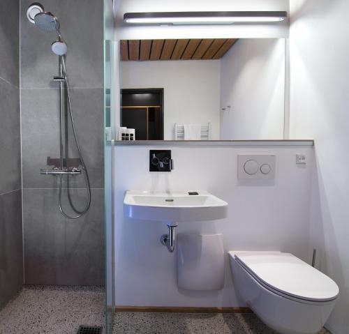 a bathroom with a sink and a toilet and a shower at Kysthotellet in Grenå