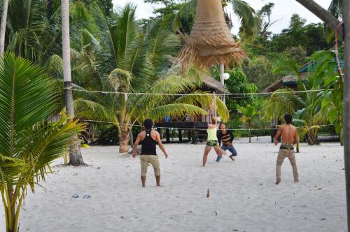 a group of men playing a game of volleyball on a beach at Palm Beach Bungalow Resort in Koh Rong Island