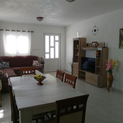 a living room with a table with chairs and a television at Vila Rogač in Tivat