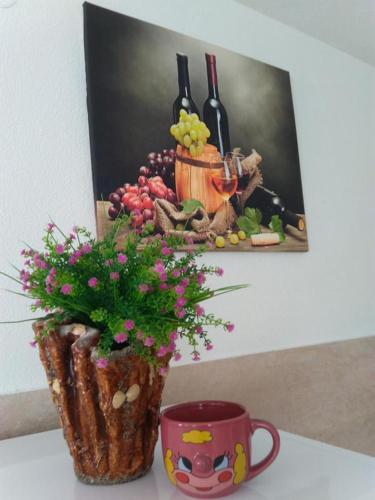 a painting of wine bottles and a vase with flowers at Vila Rogač in Tivat