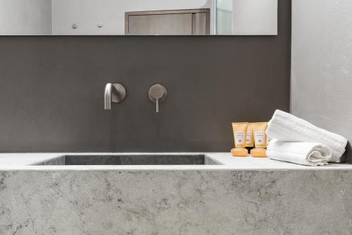 a bathroom with a sink with towels and a mirror at Elysium Suites collection in Rome