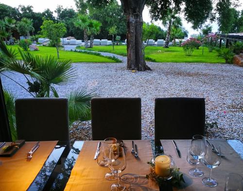 a wooden table with wine glasses on top of it at Vallegrande Nature Resort by Geocharme in Cefalù
