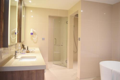 a bathroom with a sink and a shower at Novotel Taiping in Taiping