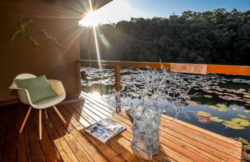 a deck with a chair and a view of a body of water at Bambuu Lakeside Lodge in Hazyview