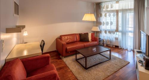uma sala de estar com um sofá e uma mesa em Luxury City Center Apartments em Helsínquia