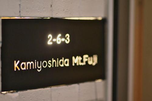 a sign on the side of a brick wall at Hostel 1889 in Fujiyoshida