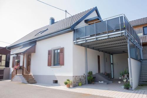 a white house with a balcony and a staircase at Gite Jehl GO10 in Artolsheim