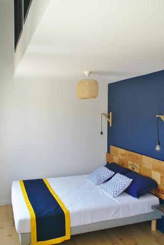 une chambre avec un lit avec un mur bleu dans l'établissement L'Estampe, à Montagne