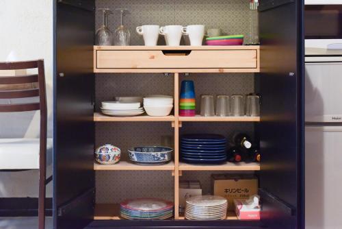 a cabinet filled with plates and bowls and dishes at Yoyogi House in Tokyo