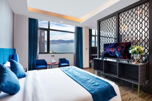 a bedroom with a large bed and a large window at Aaron Hotel in Nha Trang