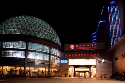 a large building with a sign on it at night at Ramada Plaza Sino-Bay Shanghai in Fengxian