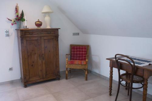 a room with a wooden cabinet and a table and chairs at Gite Jehl GO10 in Artolsheim
