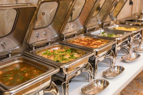 a row of trays filled with food on a table at Aaron Hotel in Nha Trang