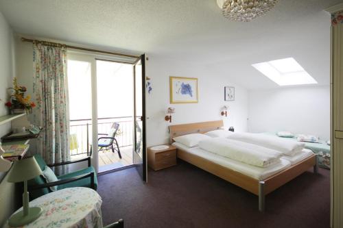 um quarto com uma cama grande e uma varanda em Gästehaus Marlies Keutschach am See em Keutschach am See