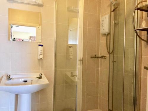 W łazience znajduje się umywalka i prysznic. w obiekcie The Northdale Hotel Ltd w Skegness