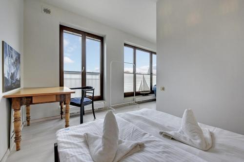 グダニスクにあるApartamenty Apartinfo Szafarniaのベッドルーム1室(ベッド1台、デスク、窓付)