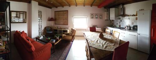 a living room with a table and a kitchen at Cherry House B&B in Polinago