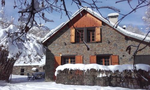 uma casa de tijolos com neve no telhado em La Grange Des Biches em Benque-Dessous-et-Dessus