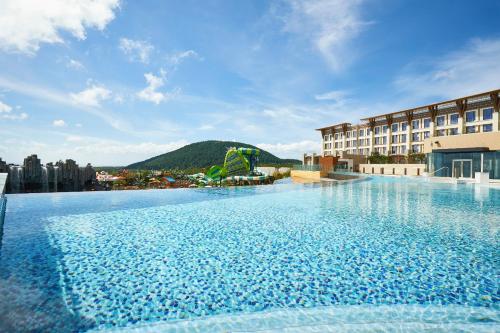 a large swimming pool on the side of a building at Shinhwa Jeju Shinhwa World Hotels in Seogwipo