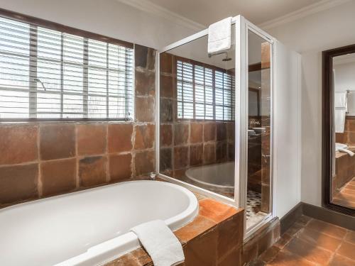 Glenburn Lodge & Spa في ملدرزدريفت: حمام كبير مع حوض استحمام ودش