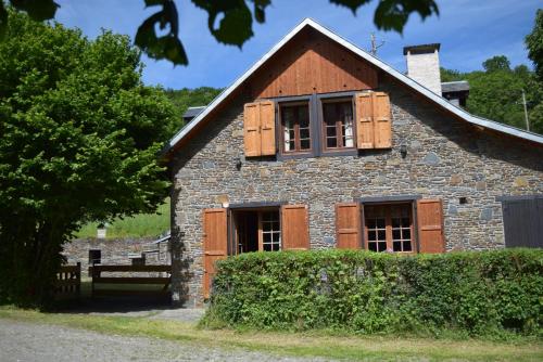 Casa de piedra antigua con ventanas de madera con contraventanas en La Grange Des Biches, en Benque-Dessous-et-Dessus