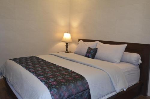 sypialnia z dużym łóżkiem z lampką w obiekcie Puri Bintang w mieście Nusa Dua