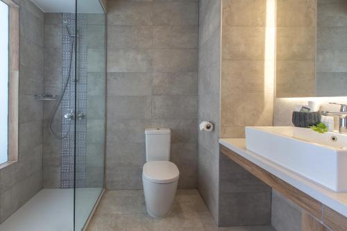a bathroom with a shower, toilet, sink and tub at Lordos Beach Hotel & Spa in Larnaca