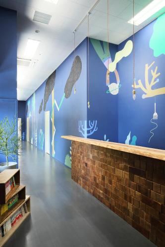 a room with a blue wall with fish on it at Iruka Hostel in Toyama