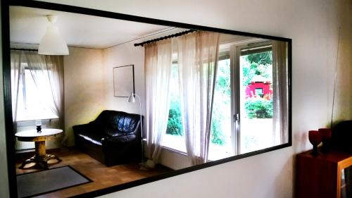 espejo que refleja una habitación con silla y ventana en Boda, en Boda