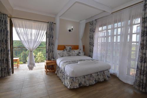 a bedroom with a bed and a large window at Bubbles Restaurant Thika in Thika