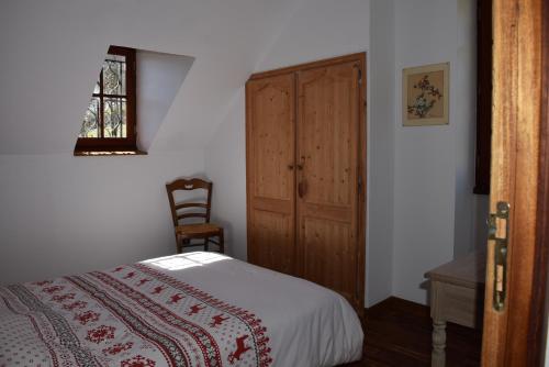 a bedroom with a bed and a wooden cabinet at La Grange Des Biches in Benque-Dessous-et-Dessus