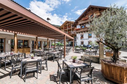 a restaurant with tables and chairs in a courtyard at Apartment Lodge Gasserhof in Bressanone