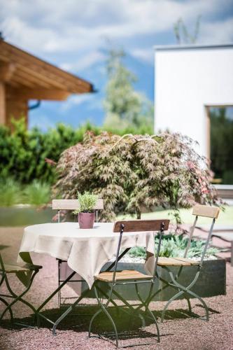 a table with two chairs and a table with plants on it at Apartment Lodge Gasserhof in Bressanone