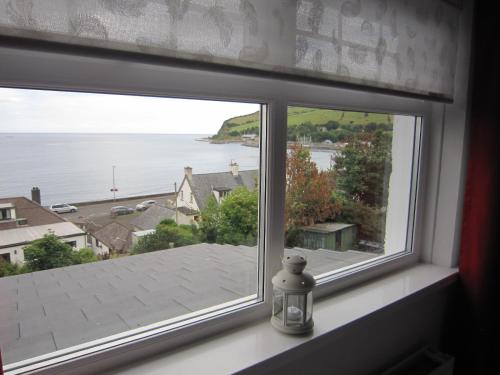 a window with a view of the water at The Lookout, Glenarm in Glenarm