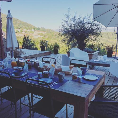 a wooden table with plates of food on a patio at Casa Santa Lucia in Bocognano