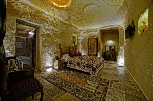 a bedroom with a bed in a stone room at NOSTALJİ CAVE SUİT HOTEL in Nevşehir