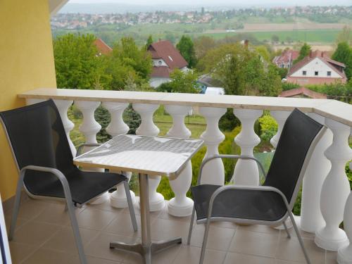 a balcony with a table and chairs and a view at Hévíz -Alsópáhok Villa-Erika Apartman in Alsópáhok