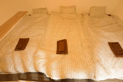 a bed with a white comforter with four pillows at Yoyogi House in Tokyo