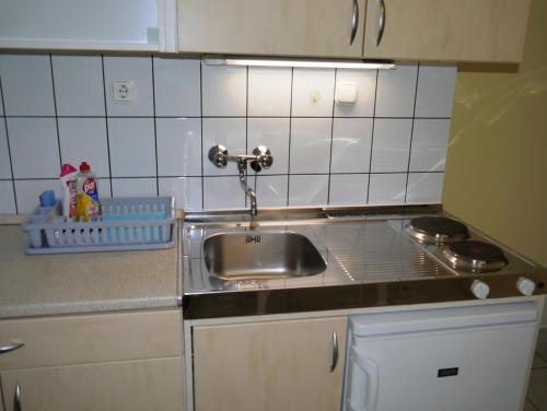 eine Küche mit einer Spüle und einer Arbeitsplatte in der Unterkunft Hévíz Villa-Erika Apartman in Alsópáhok