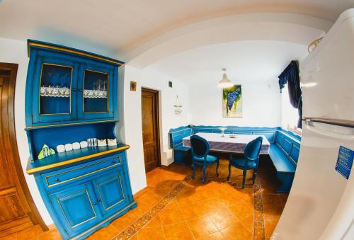 a dining room with blue cabinets and a table at Cabana Dintre Vii in Apoldu de Sus