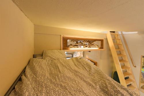 a small bedroom with a bed and a ladder at Yoyogi House in Tokyo