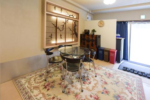 a dining room with a glass table and chairs on a rug at Yoyogi House in Tokyo