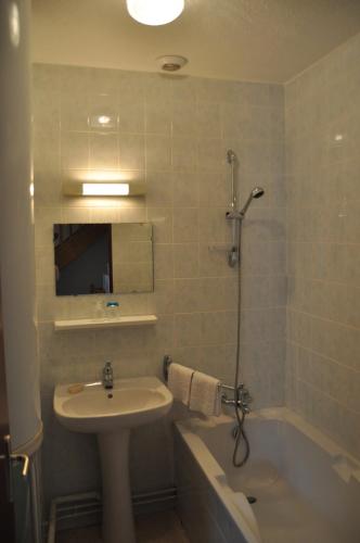 a bathroom with a sink and a bath tub and a sink at Maison vedrines saint loup cantal in Montchamp