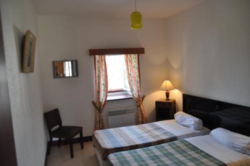 een hotelkamer met 2 bedden en een raam bij Maison vedrines saint loup cantal in Montchamp