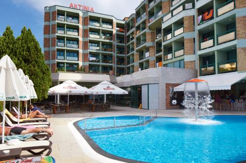 a swimming pool with a fountain in front of a building at Hotel Aktinia - All Inclusive in Sunny Beach