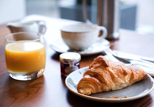 a plate with a croissant and a glass of orange juice at The Beverley Arms Hotel in Beverley