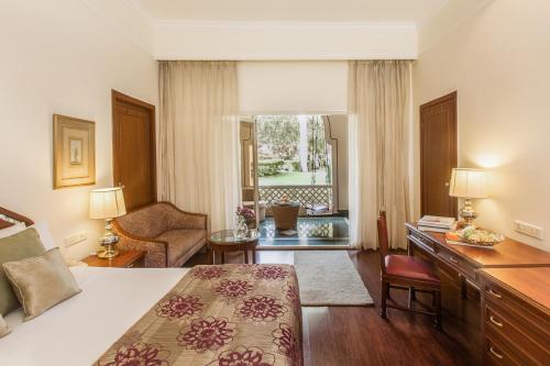 a hotel room with a bed and a desk and a window at Vivanta Aurangabad, Maharashtra in Aurangabad